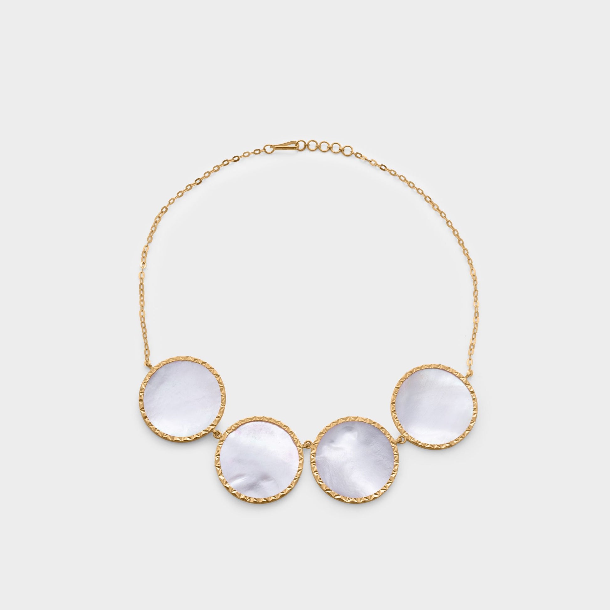 A delicate 21-karat gold necklace with a mother-of-pearl charm.